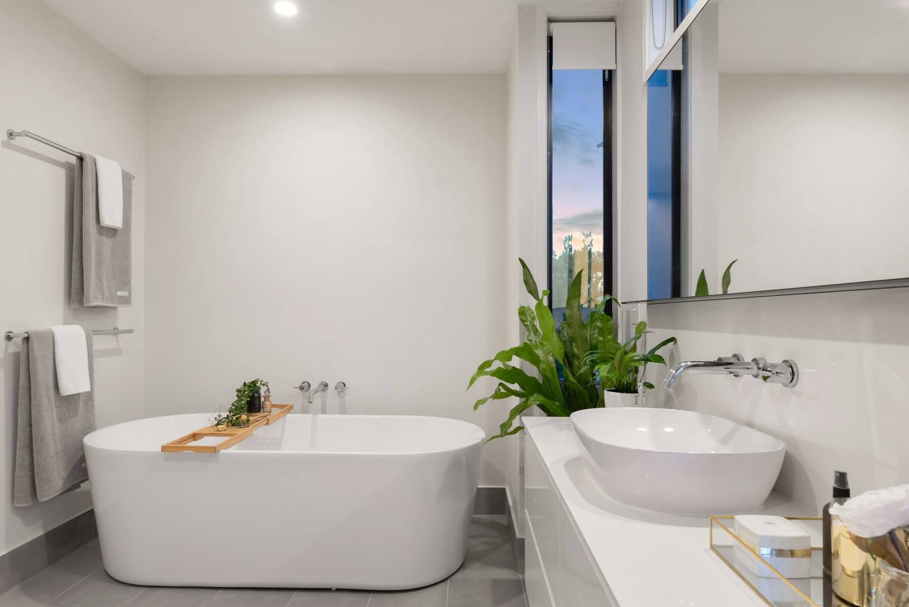 White bathtub beside a green potted plant