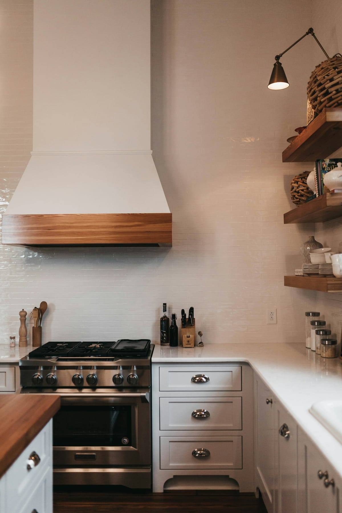 Clean white kitchen with a range hood and open shelves