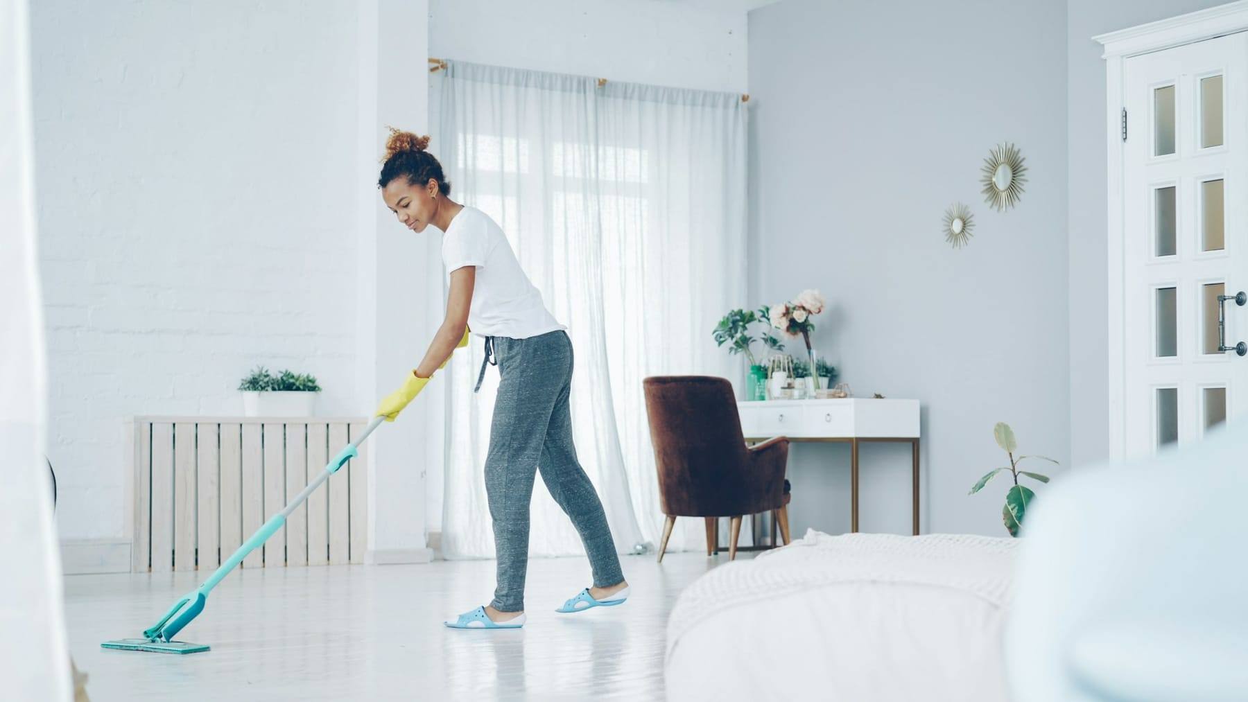 Person mopping a bright, airy living room