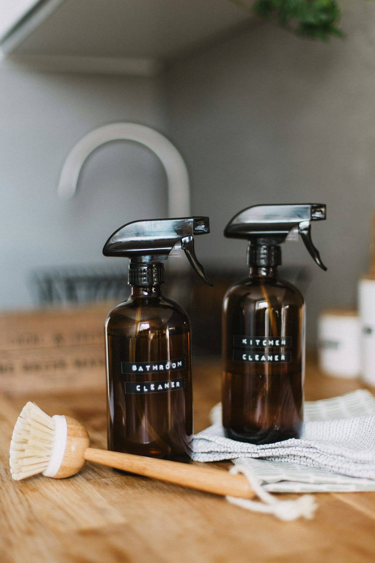 Two amber glass spray bottles of cleaner
